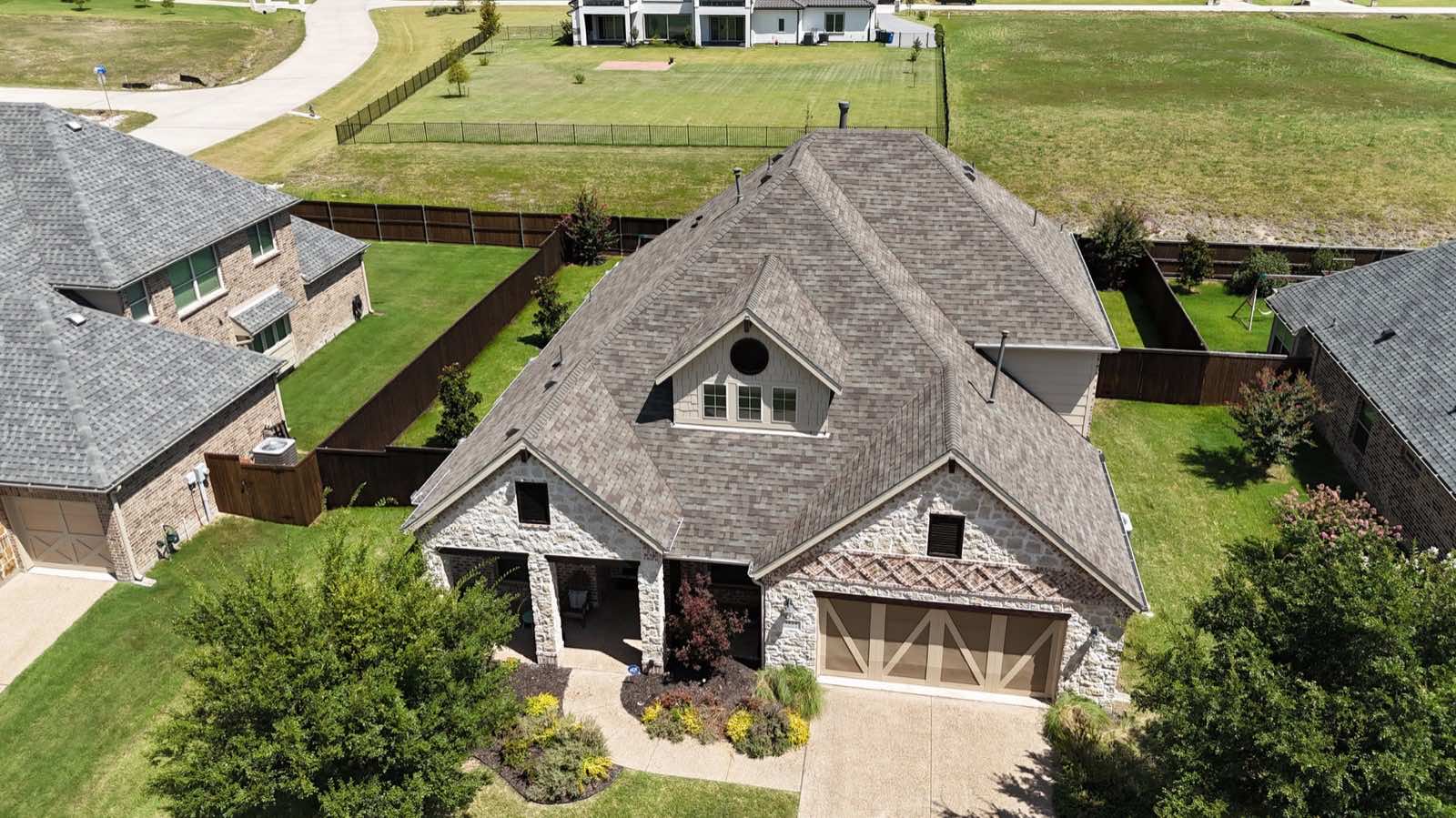 Stone home with a new architectural shingle roof installed by Skyline