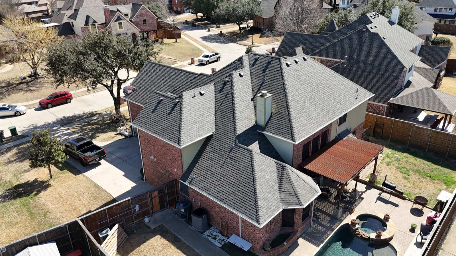 Aerial view of a home with a pool and a new roof