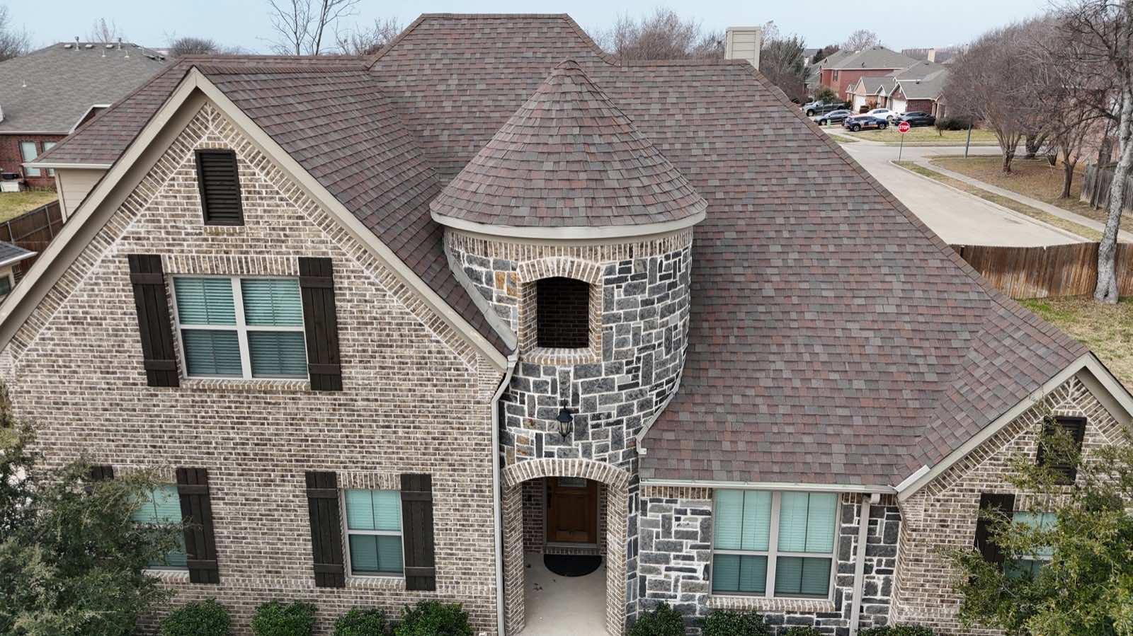 Stone turret and brick home with a new roof